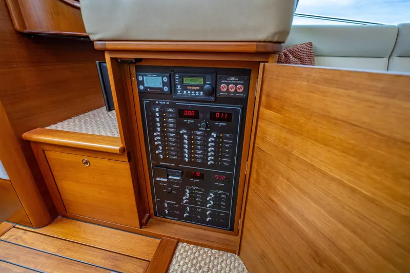 Slide: The Image of 2020 Palm Beach Motor Yachts PB50 electrical panel with wooden cabinetry interior. - 32