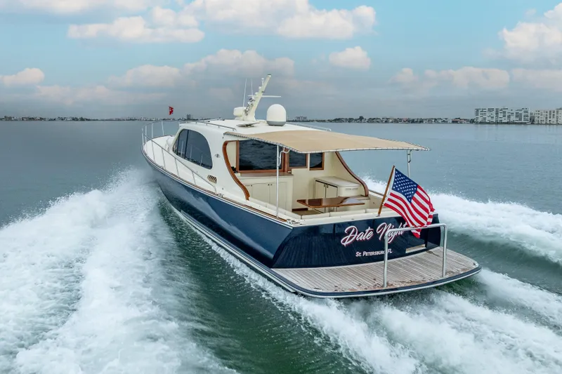 Slide: The Image of 2020 Palm Beach Motor Yachts PB50 cruising on water, rear view with American flag. - 6