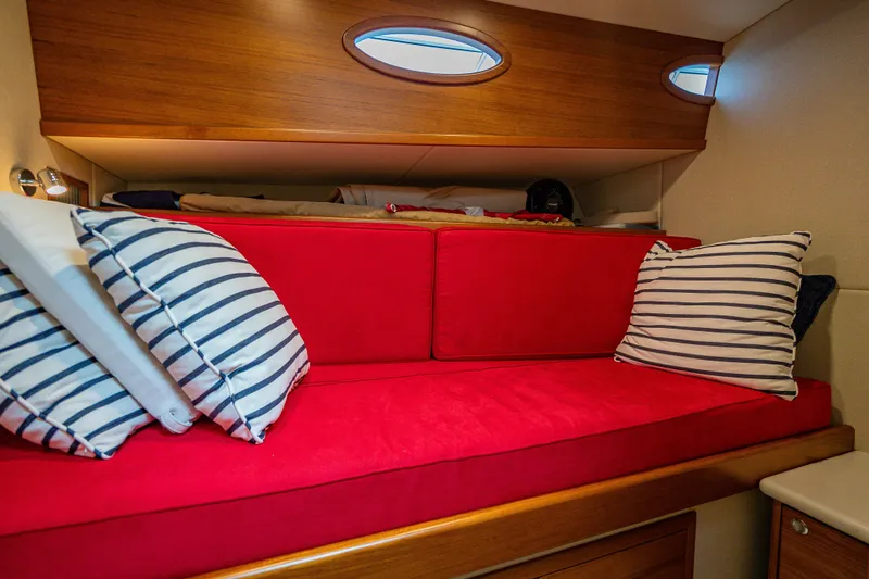 Slide: The Image of 2020 Palm Beach Motor Yachts PB50 cabin with red seating and striped pillows. - 41