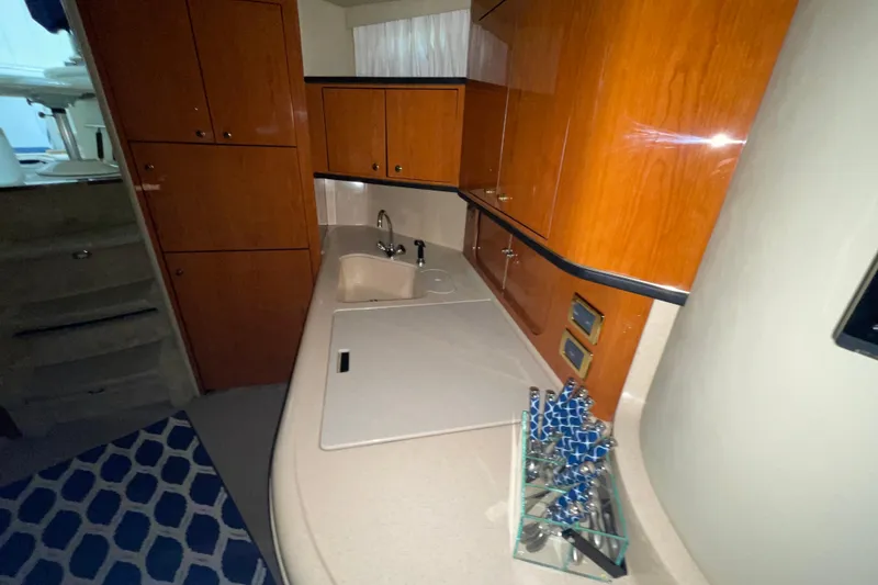Slide: The Image of 2001 Sea Ray Sundancer 460 yacht interior with wooden cabinets and modern kitchenette. - 14