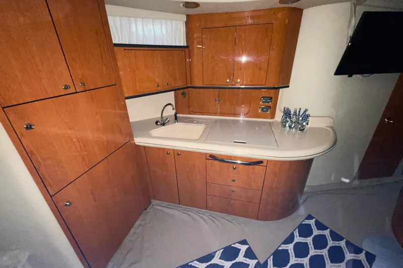 Slide: The Image of 2001 Sea Ray Sundancer 460 yacht kitchen with wooden cabinets and modern sink. - 16
