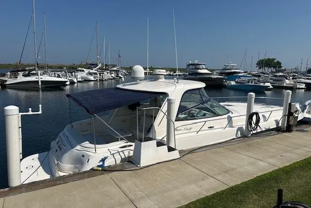 Slide: The Image of 2001 Sea Ray 460 Sundancer yacht docked at marina under clear blue sky. - 3
