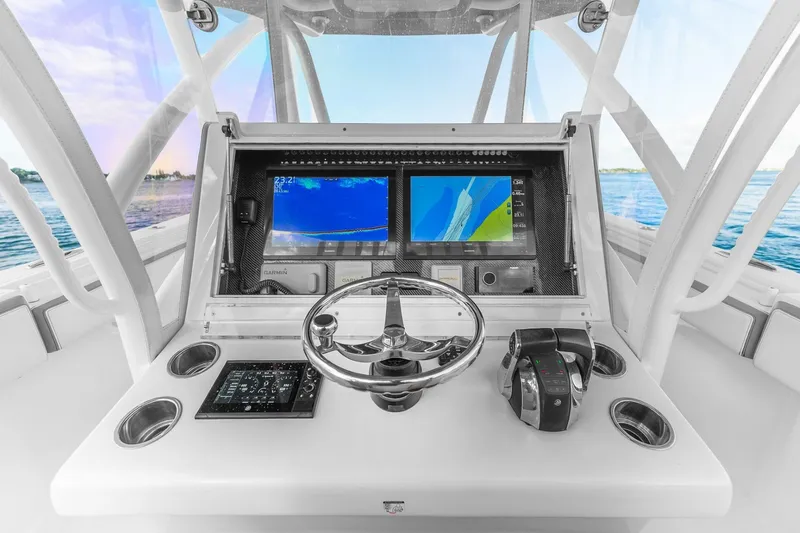 Slide: The Image of 2021 SeaHunter 39 Tournament boat dashboard with dual navigation screens and steering wheel. - 8