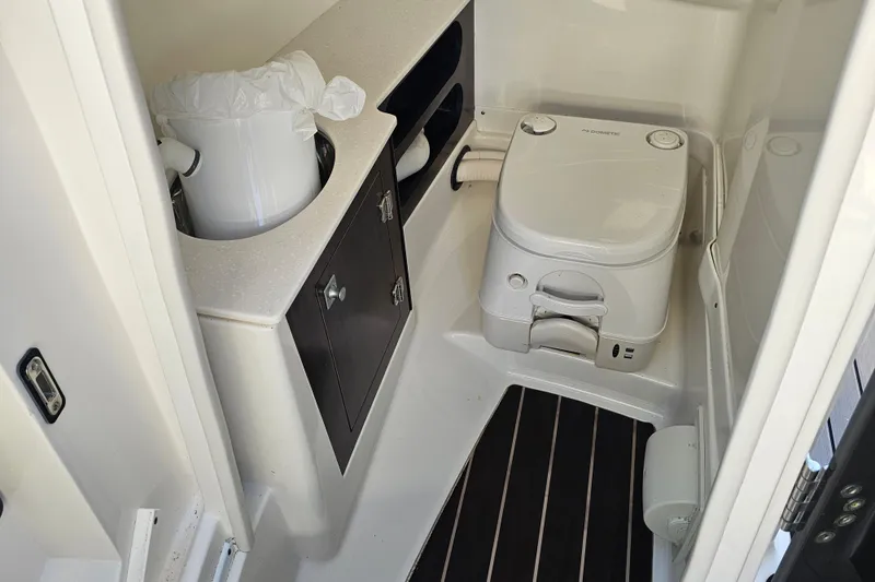 Slide: The Image of 2020 Monterey 275SS Super Sport boat bathroom with compact toilet and storage cabinet. - 21