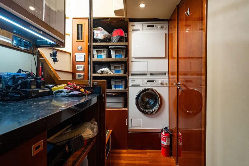Slide: The Image of Laundry area on 2010 Princess 95 Motor Yacht with washer, dryer, and storage shelves. - 172