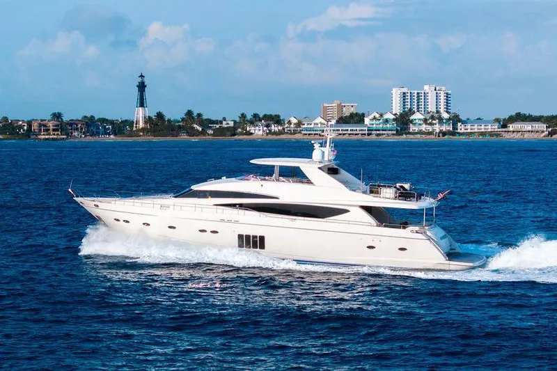 Slide: The Image of 2010 Princess 95 Motor Yacht cruising near a coastal lighthouse and cityscape. - 49