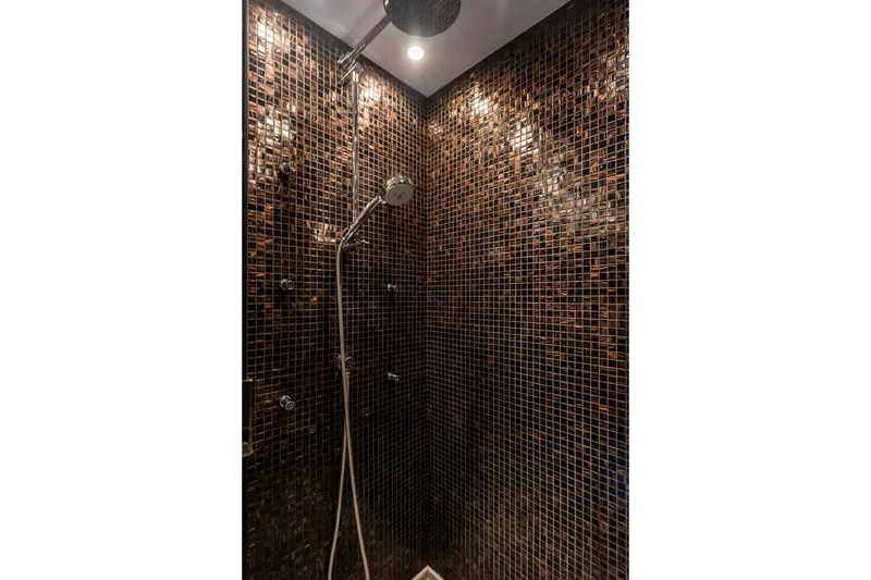 Slide: The Image of Luxurious shower with dark mosaic tiles in a 2010 Princess 95 Motor Yacht. - 84