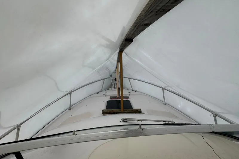 Slide: The Image of 2005 Grady-White Express 265 boat under protective cover, showcasing deck and railings. - 10