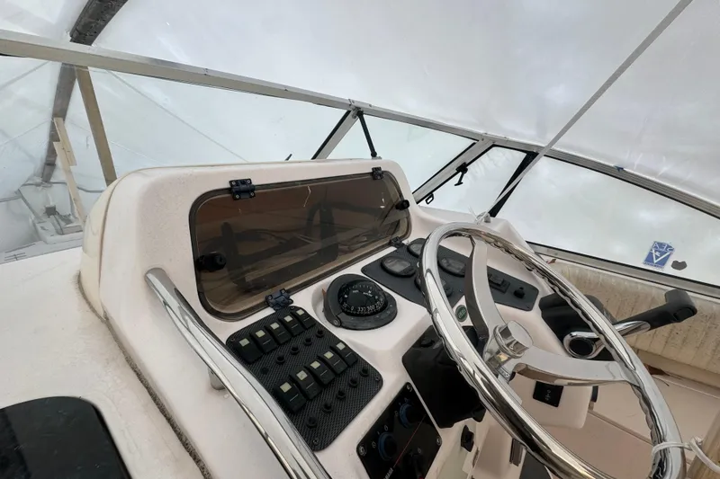 Slide: The Image of 2005 Grady-White Express 265 boat helm with steering wheel and navigation controls. - 11