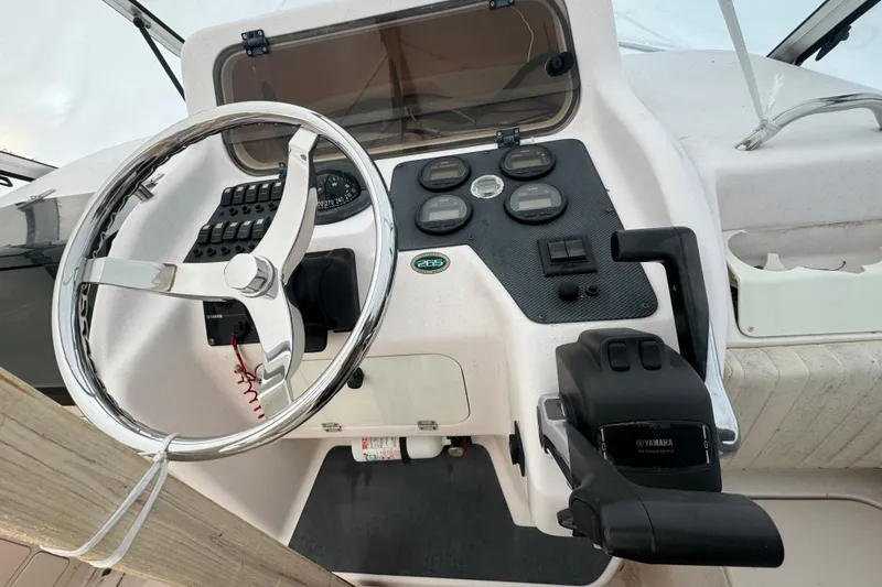 Slide: The Image of 2005 Grady-White Express 265 boat dashboard with steering wheel and controls. - 15