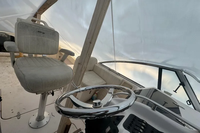 Slide: The Image of 2005 Grady-White Express 265 boat interior with steering wheel and seating. - 16