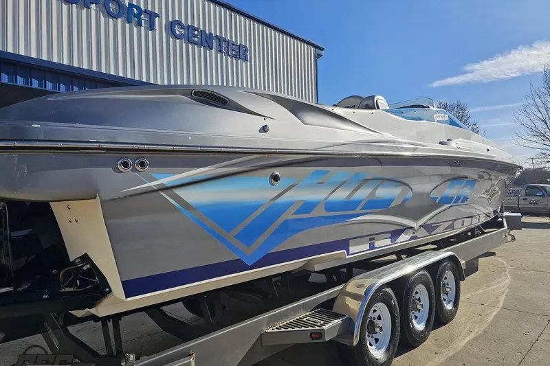 Slide: The Image of 2007 Hustler 41 Razor boat on trailer outside a sport center. - 10