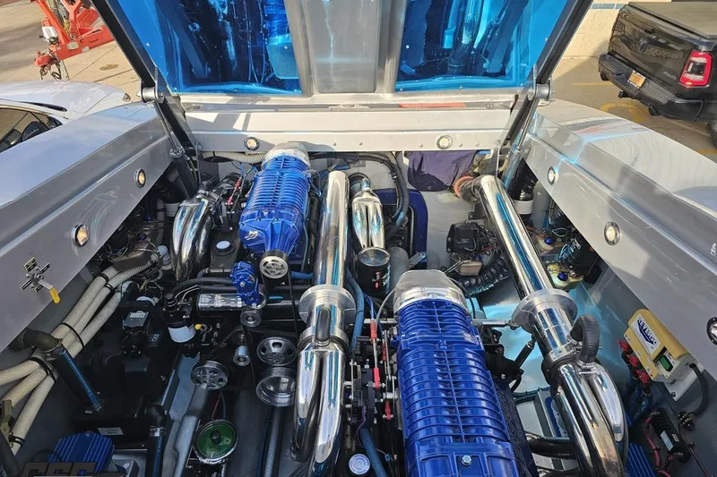 Slide: The Image of Engine compartment of a 2007 Hustler 41 Razor boat, featuring blue and chrome components. - 101