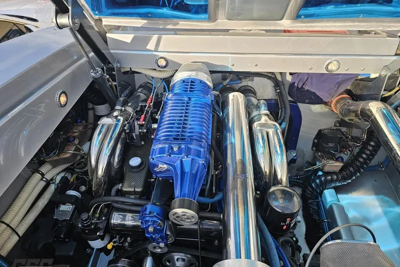 Slide: The Image of Engine compartment of a 2007 Hustler 41 Razor with blue supercharger and chrome components. - 102