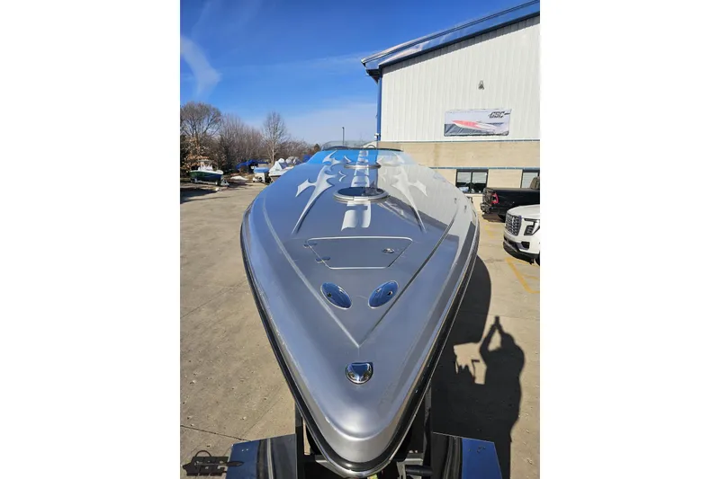 Slide: The Image of 2007 Hustler 41 Razor boat with sleek design, parked outdoors under clear blue sky. - 14