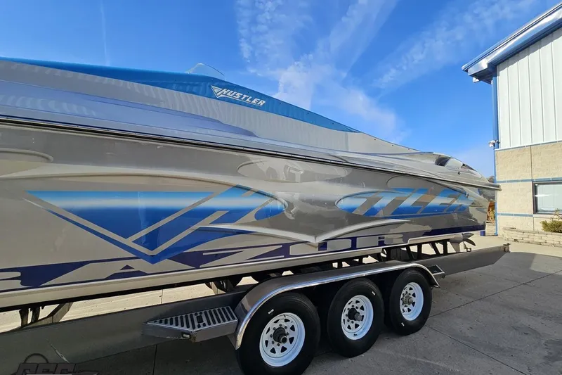 Slide: The Image of 2007 Hustler 41 Razor boat on trailer, featuring sleek blue and silver design. - 19