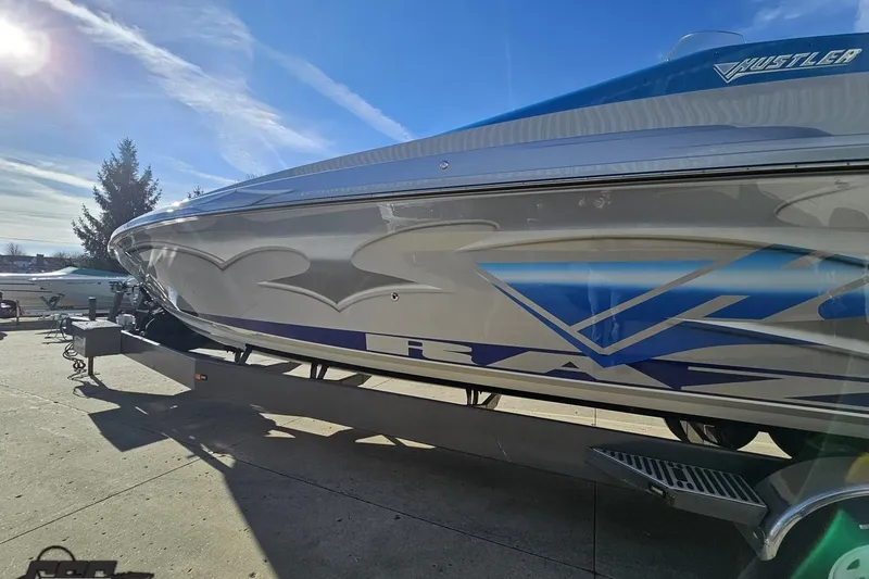 Slide: The Image of 2007 Hustler 41 Razor boat with sleek design and vibrant graphics on a sunny day. - 22