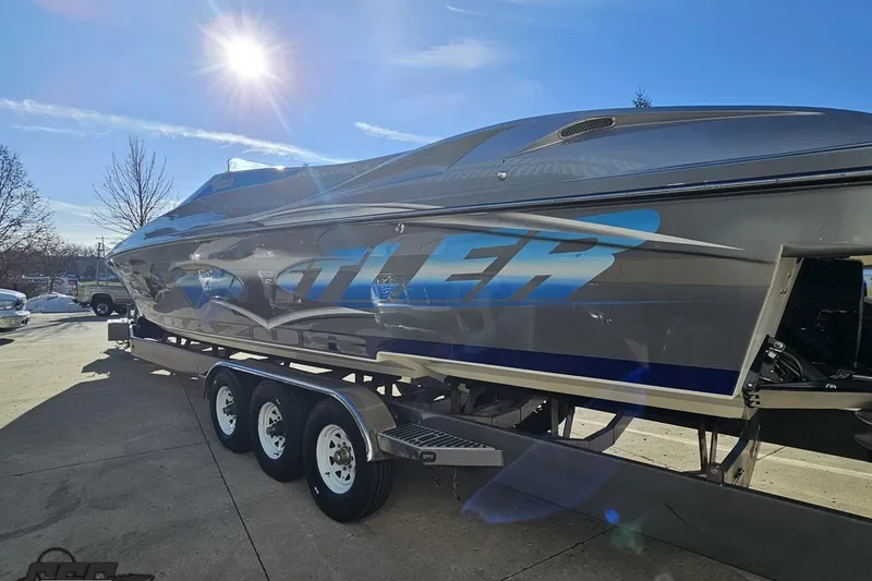 Slide: The Image of 2007 Hustler 41 Razor boat on trailer under bright sun. - 25