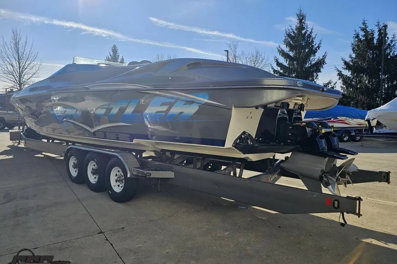 Slide: The Image of 2007 Hustler 41 Razor speedboat on trailer, sleek design, parked outdoors. - 26