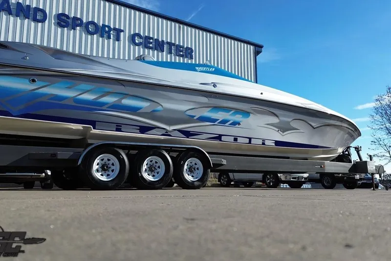 Slide: The Image of 2007 Hustler 41 Razor boat on trailer at sport center, clear sky background. - 33