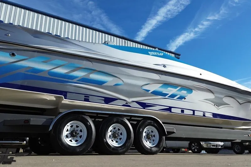 Slide: The Image of 2007 Hustler 41 Razor boat on trailer, showcasing sleek design and vibrant graphics. - 34