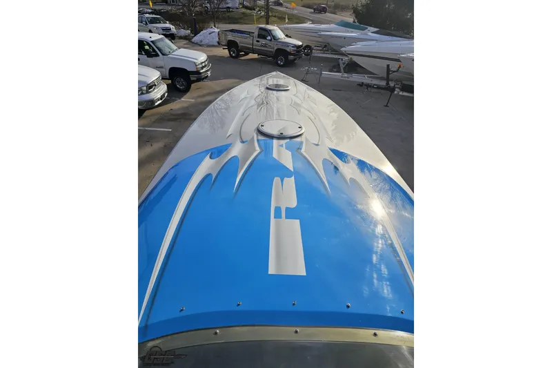 Slide: The Image of 2007 Hustler 41 Razor boat with blue and white design in a parking lot. - 71