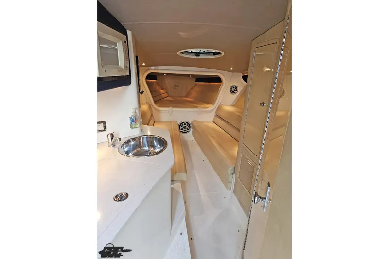 Slide: The Image of Interior of 2007 Hustler 41 Razor boat, featuring kitchenette and seating area. - 73