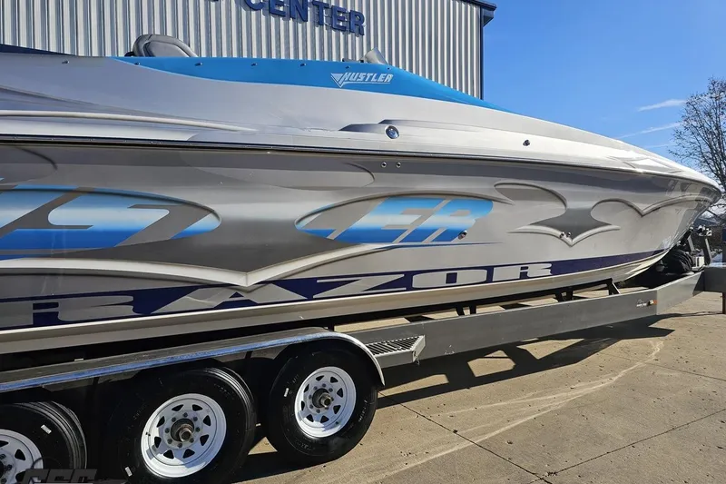 Slide: The Image of 2007 Hustler 41 Razor boat on trailer, sleek design, parked outdoors. - 8