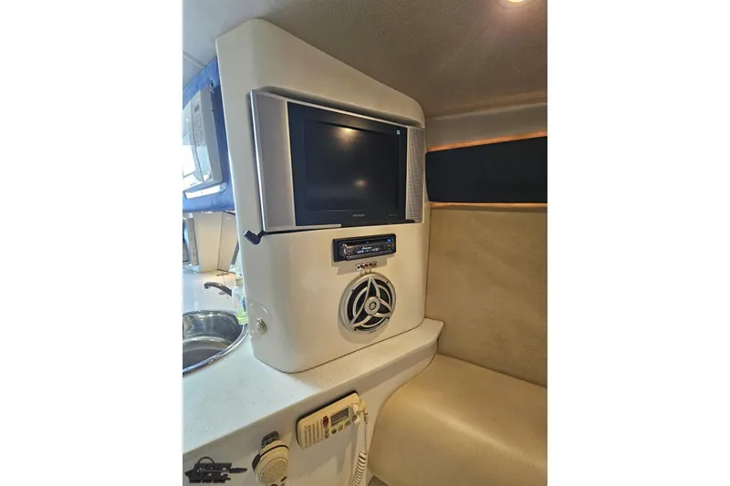 Slide: The Image of 2007 Hustler 41 Razor interior with TV, speaker, and beige seating. - 83