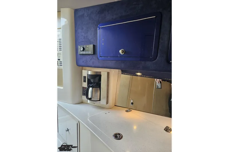 Slide: The Image of Interior of 2007 Hustler 41 Razor boat with coffee maker and blue storage compartment. - 87