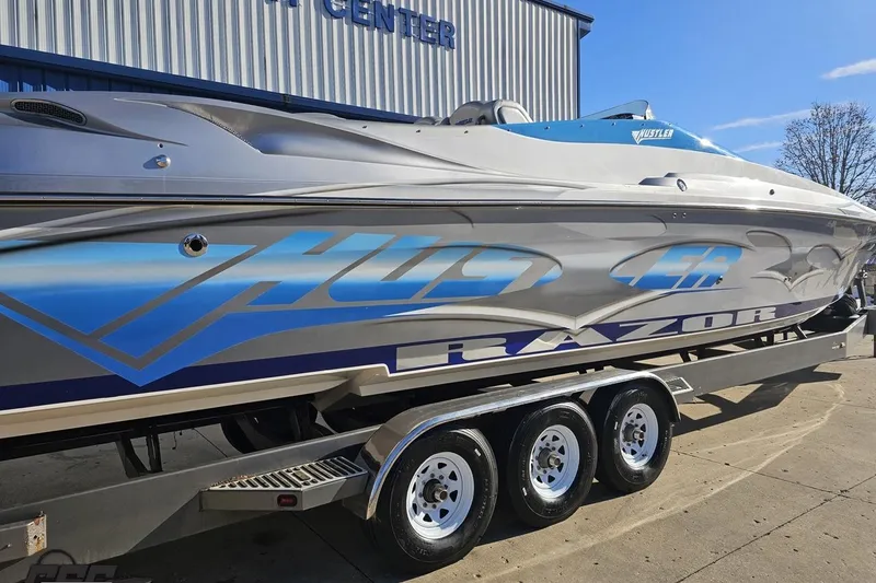 Slide: The Image of 2007 Hustler 41 Razor speedboat on trailer, featuring sleek design and vibrant graphics. - 9