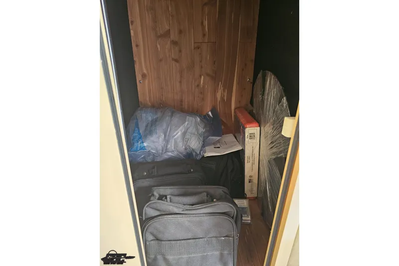 Slide: The Image of Storage compartment in a 2007 Hustler 41 Razor boat with bags and boxes. - 90