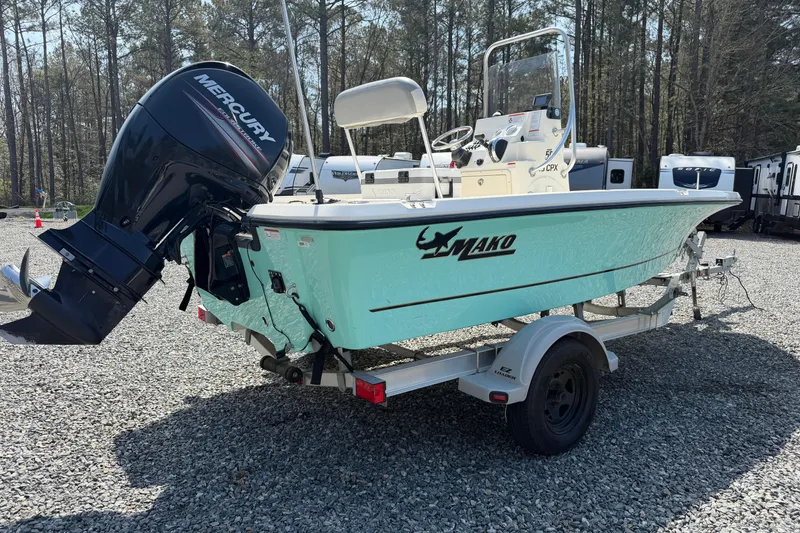 Slide: The Image of 2018 Mako 19 CPX boat with Mercury engine on trailer in wooded area. - 17