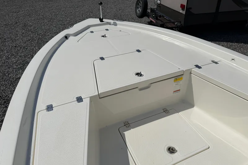 Slide: The Image of 2018 Mako 19 CPX boat deck with storage compartments and clean white finish. - 20