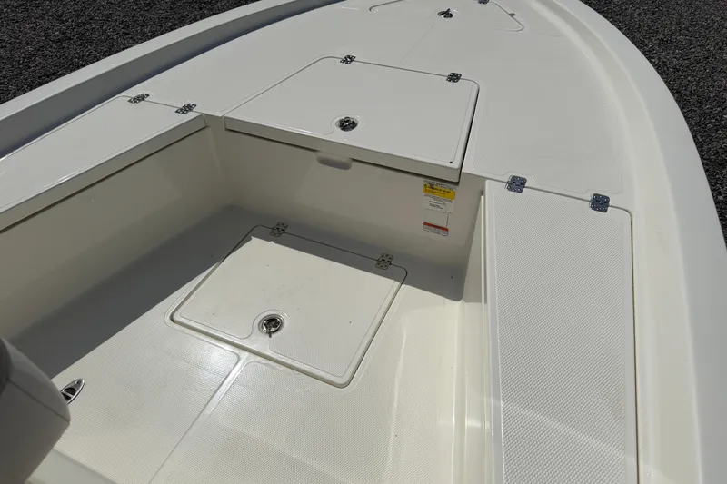 Slide: The Image of 2018 Mako 19 CPX boat deck with storage compartments and textured surface. - 23