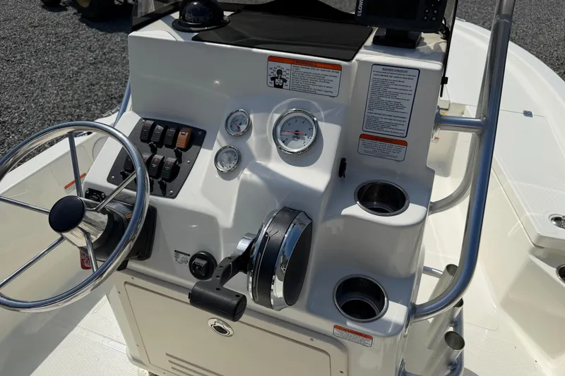Slide: The Image of 2018 Mako 19 CPX boat console with steering wheel, gauges, and controls. - 25