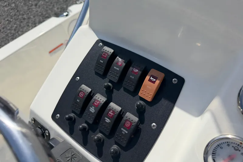 Slide: The Image of Control panel of a 2018 Mako 19 CPX boat with labeled switches. - 27