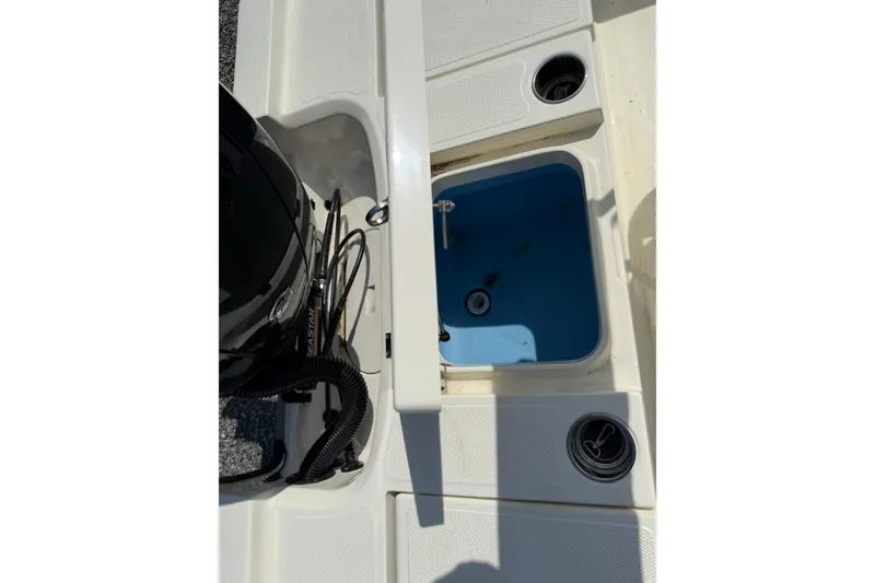 Slide: The Image of 2018 Mako 19 CPX boat interior with open storage compartment and cup holders. - 31