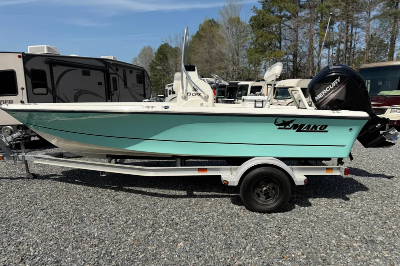 Slide: The Image of 2018 Mako 19 CPX boat on trailer, parked outdoors near RVs. - 34