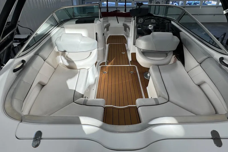 Slide: The Image of 2012 Yamaha Boats SX210 interior with white seating and wooden flooring. - 10