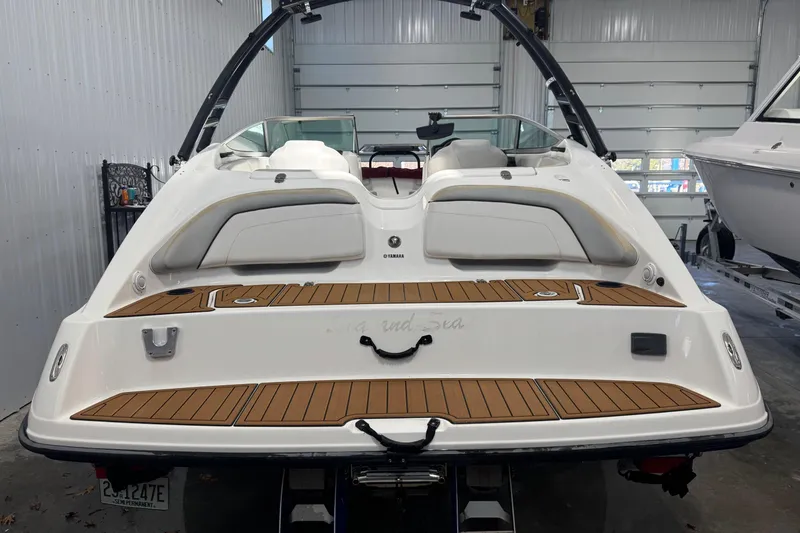 Slide: The Image of 2012 Yamaha Boats SX210 in a garage, showcasing rear deck and seating. - 12