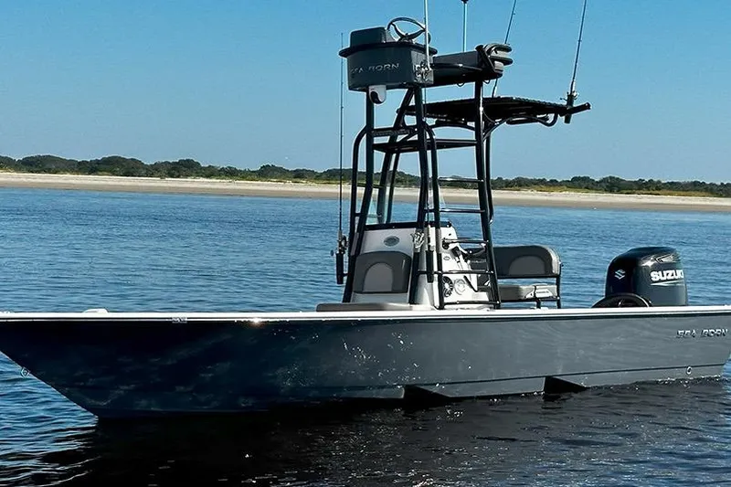 The Image of 2026 Sea Born FX24 Bay boat on calm water with Suzuki outboard motor. - 0