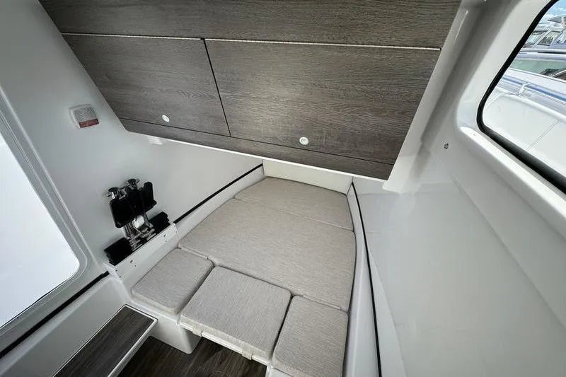 Slide: The Image of 2025 Sportsman Open 352 Center Console cabin interior with cushioned seating and storage. - 36