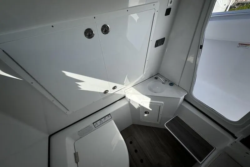Slide: The Image of Interior of 2025 Sportsman Open 352 Center Console boat, featuring compact bathroom amenities. - 38
