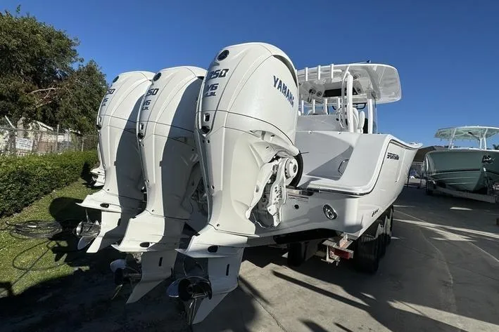 Slide: The Image of 2025 Sportsman Open 352 Center Console with triple Yamaha engines, docked outdoors. - 4