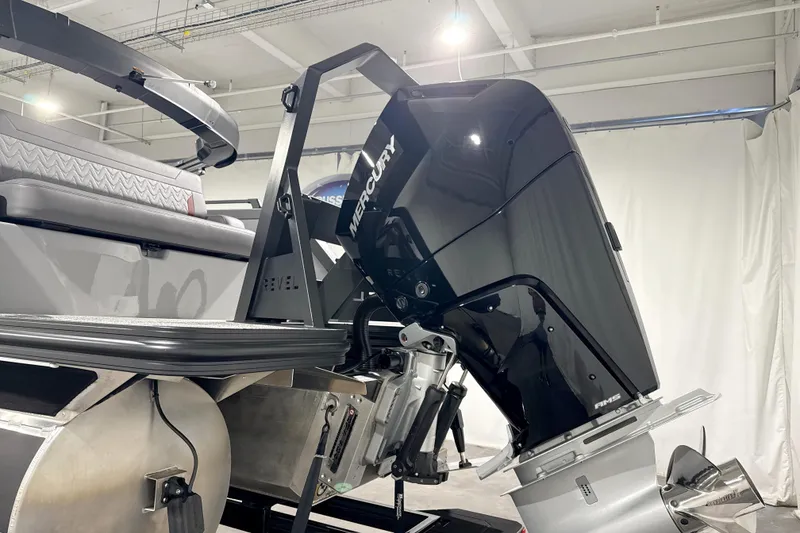 Slide: The Image of 2026 Revel RS25 boat with Mercury outboard motor in a showroom setting. - 1