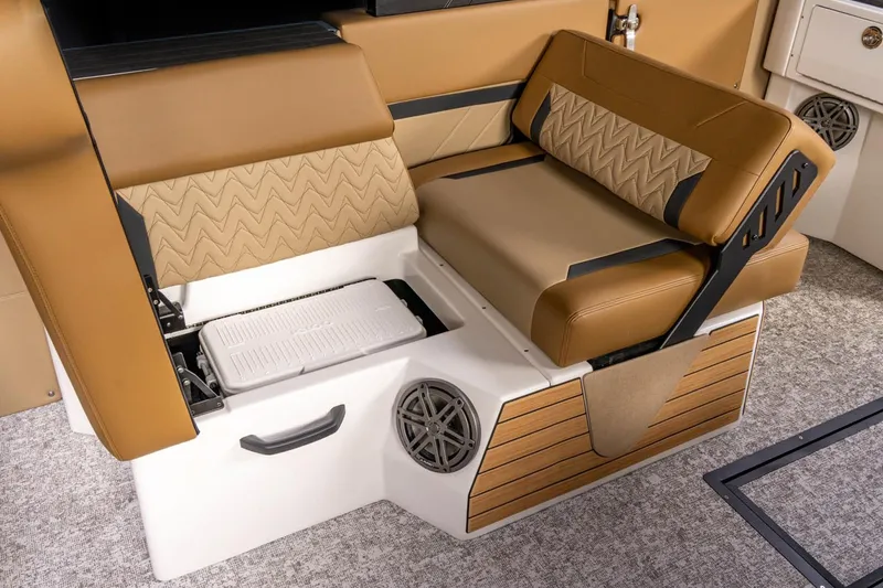Slide: The Image of Manufacturer Provided Image: 2026 Revel RS25 boat interior with tan seating, storage compartment, and speaker. - 13