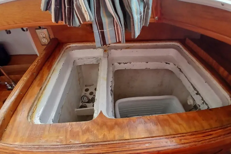 Slide: The Image of 1976 Islander Freeport boat interior with open storage compartments and wooden finish. - 11