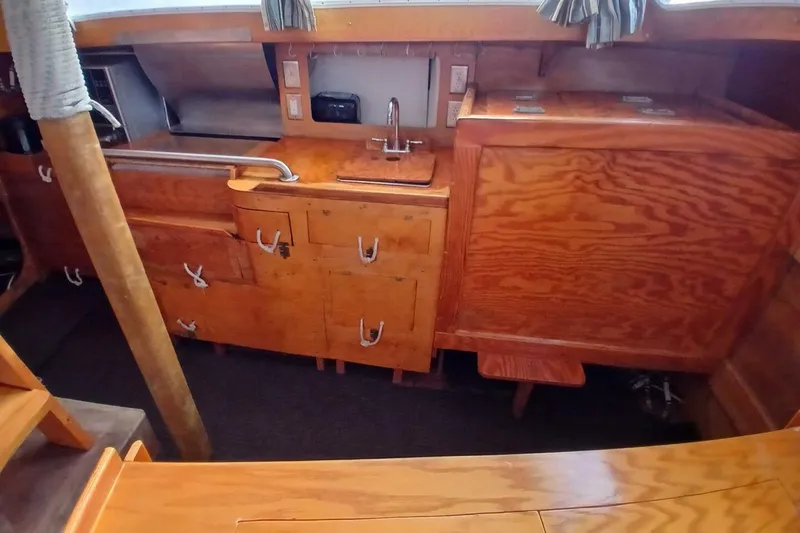 Slide: The Image of 1976 Islander Freeport yacht interior with wooden cabinetry and compact kitchen area. - 14