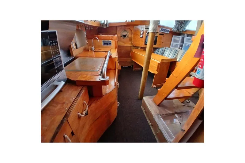 Slide: The Image of 1976 Islander Freeport yacht interior with wooden cabinetry, seating, and nautical equipment. - 15